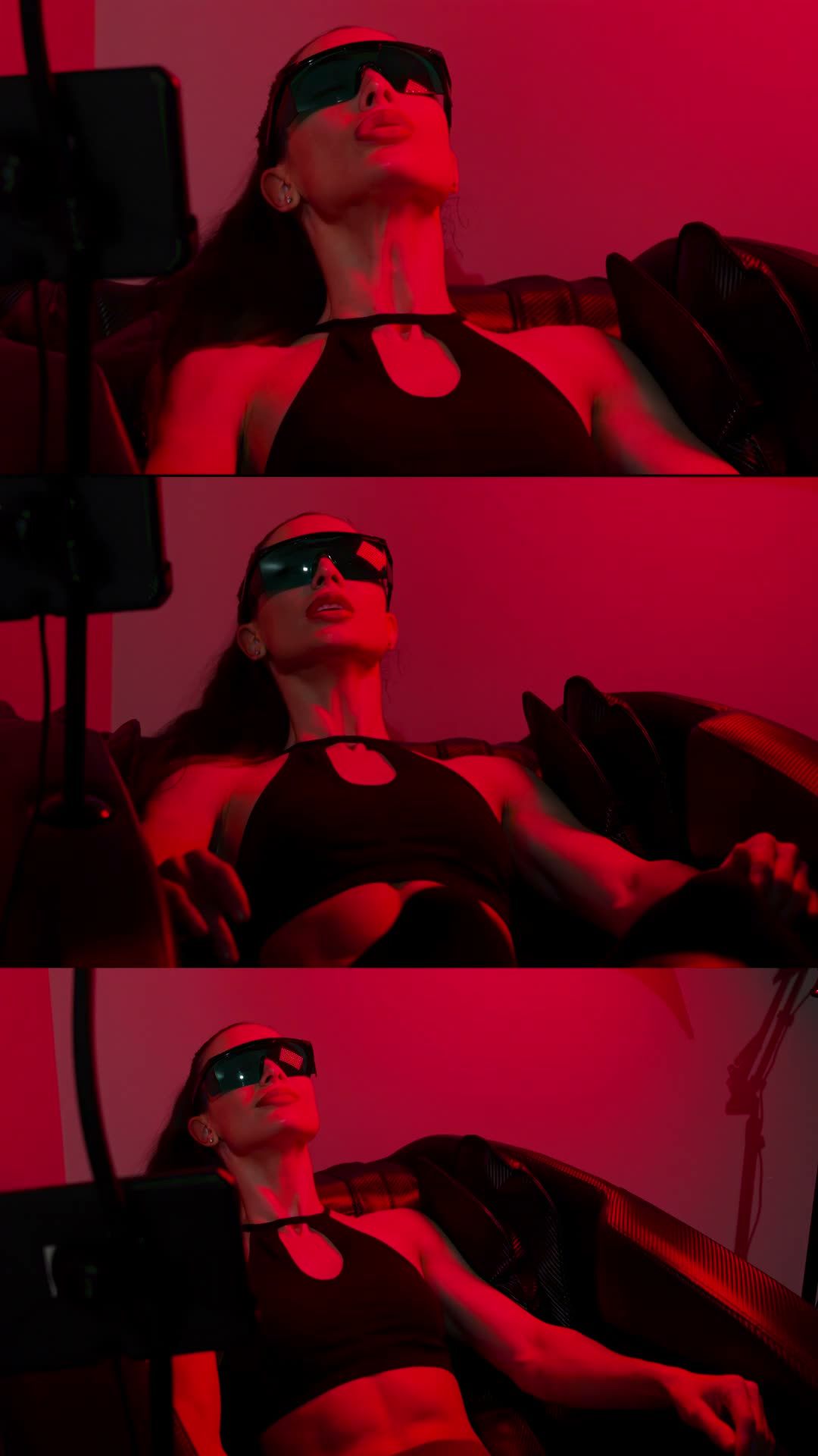 A member reclined on the anti-gravity red light lounger in protective eyewear, the room washed in deep red panel light.